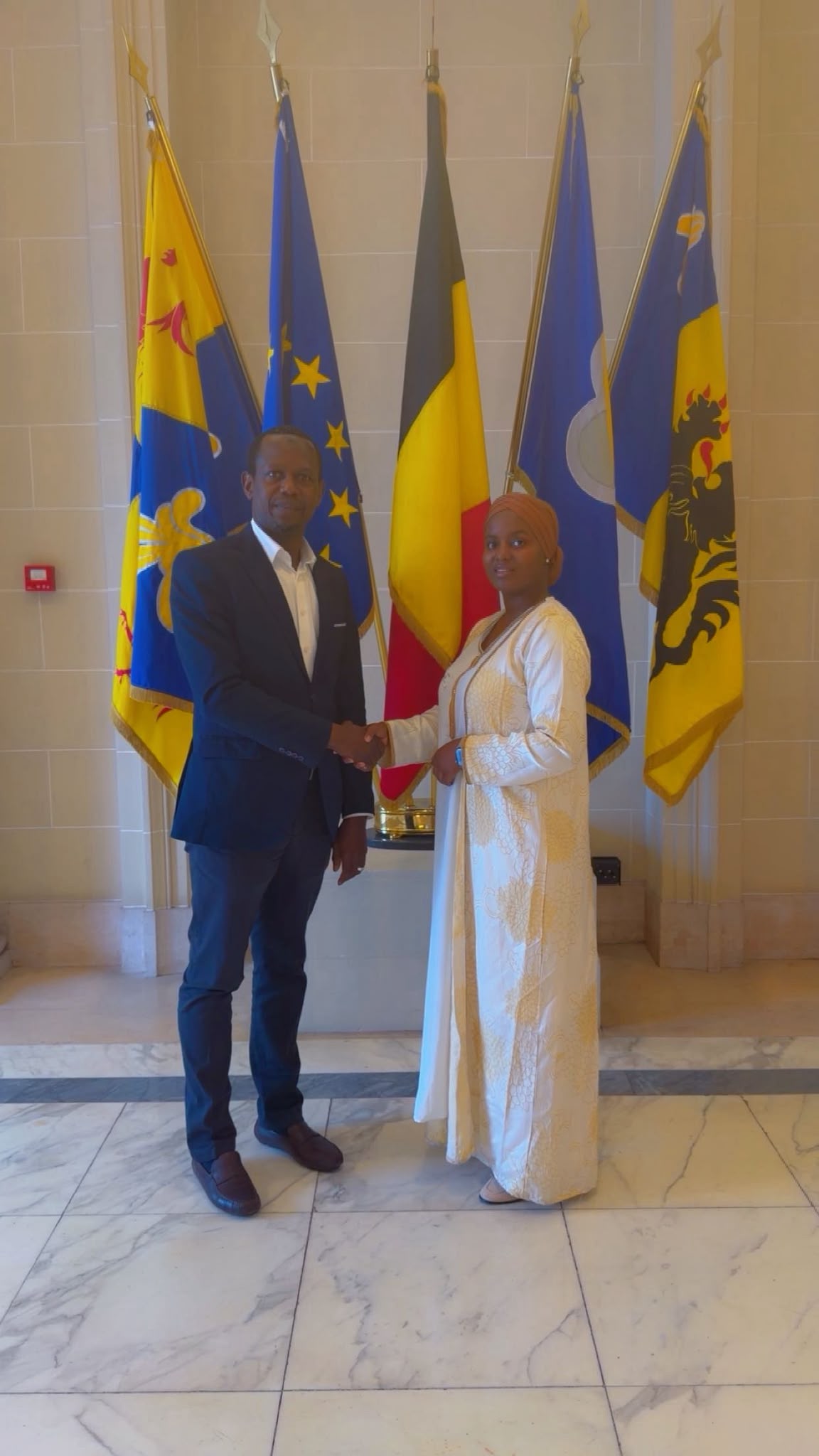 La présidente de la Fondation H.DJIDJA et le sénateur Elhadj Moussa Diallo, devant les drapeaux belges et européen